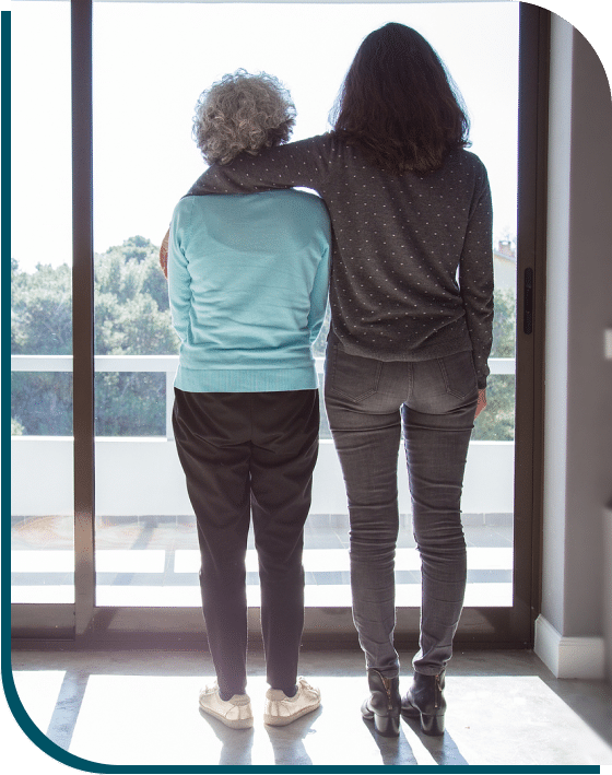 two women are standing near window photo